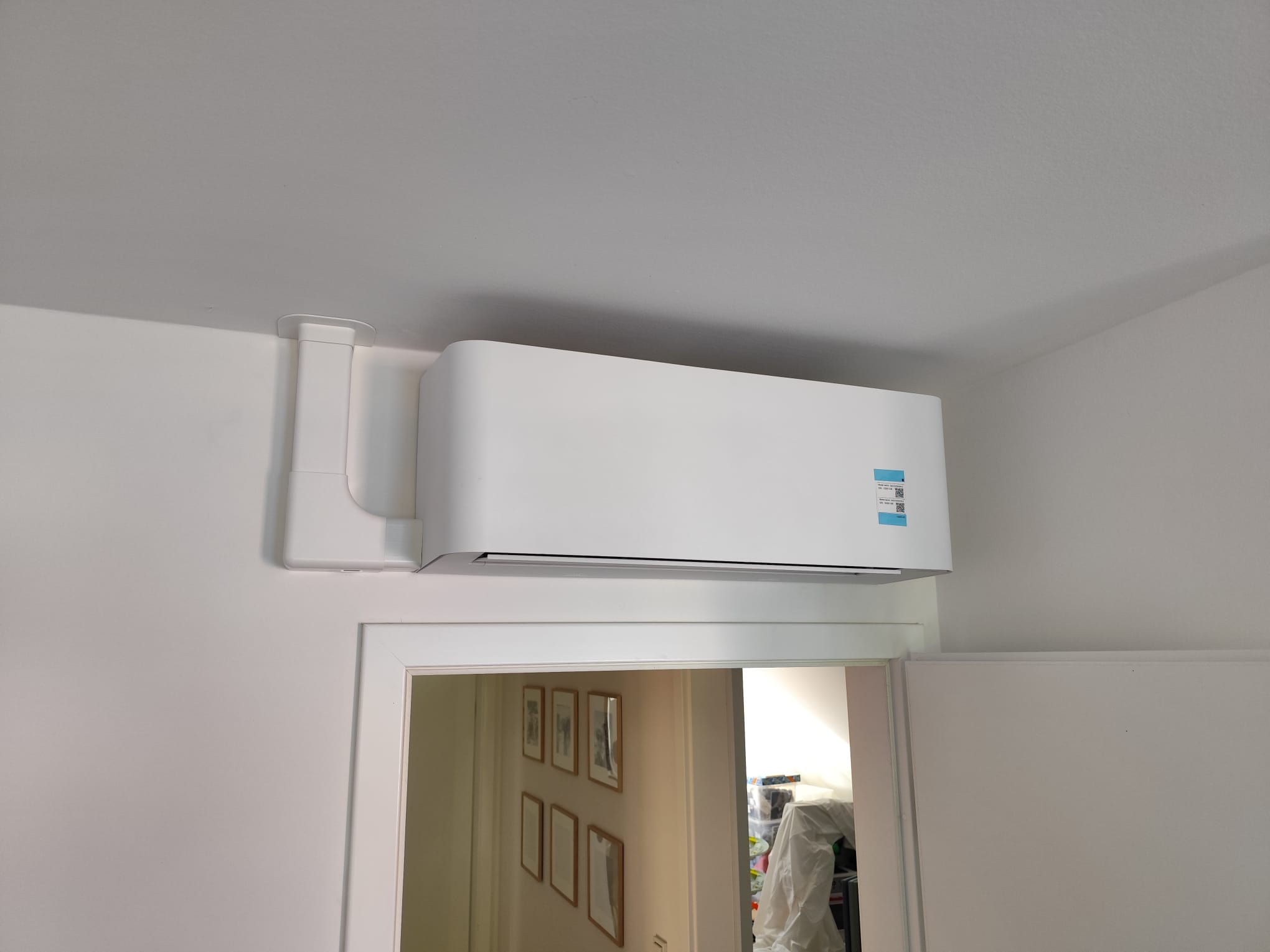 Weiße Split-Klimaanlage diskret über dem Türrahmen in einer Berliner Wohnung montiert